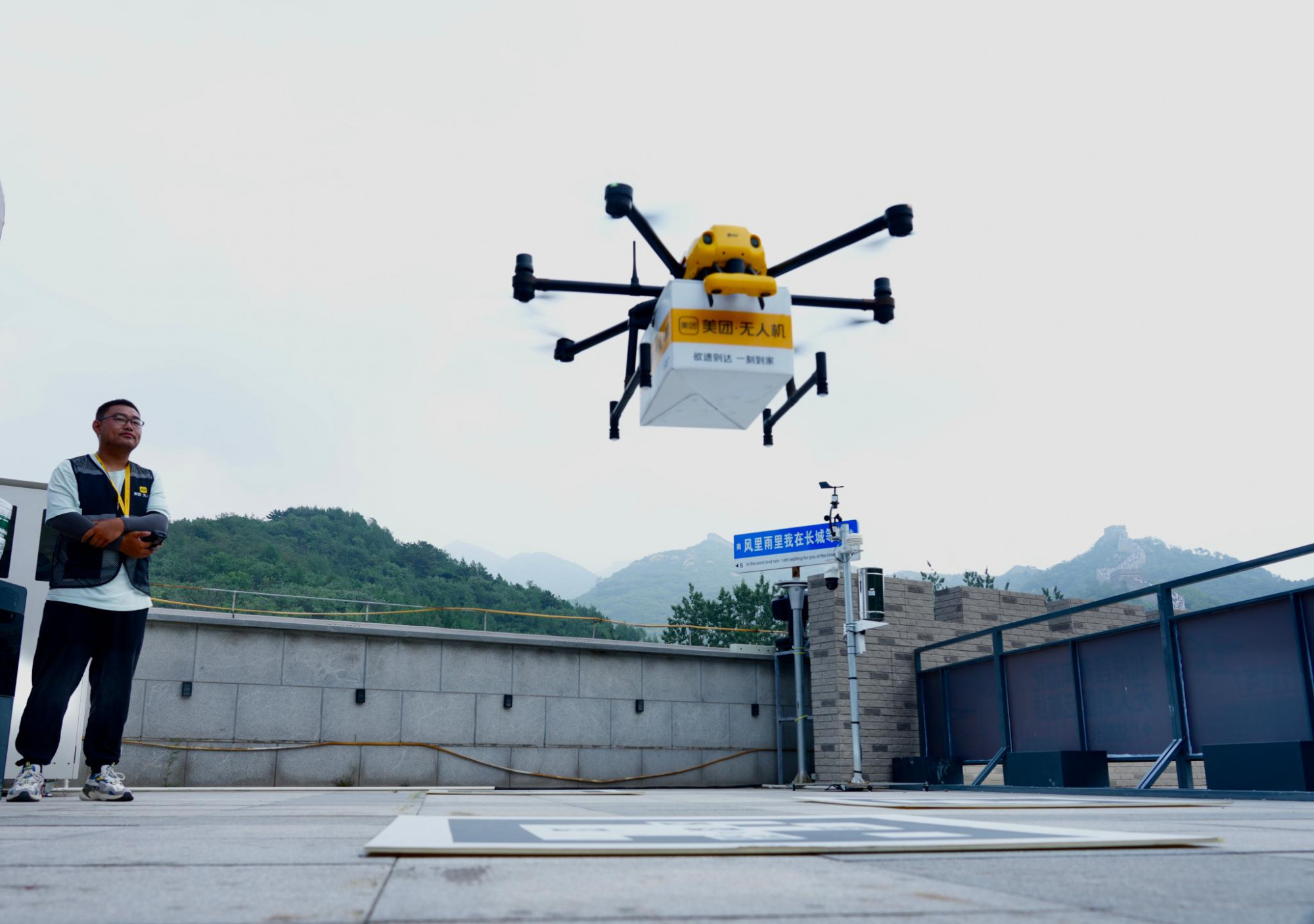 Một nhân viên đang tiếp nhận kiện hàng do drone chuyển đến - Ảnh: Huang Liang/Beijing Youth Daily/VCG via Getty Images