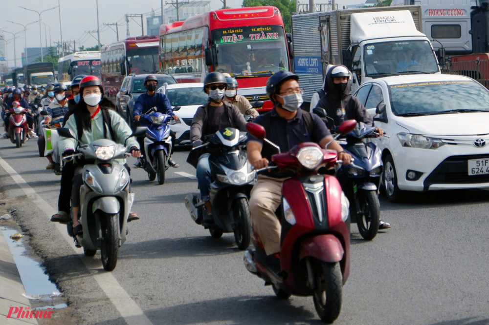 Tại cửa ngõ phía Tây TPHCM, các phương tiện di chuyển đông đúc trên Quốc lộ 1, đoạn qua huyện Bình Chánh - Ảnh: Vũ Quyền