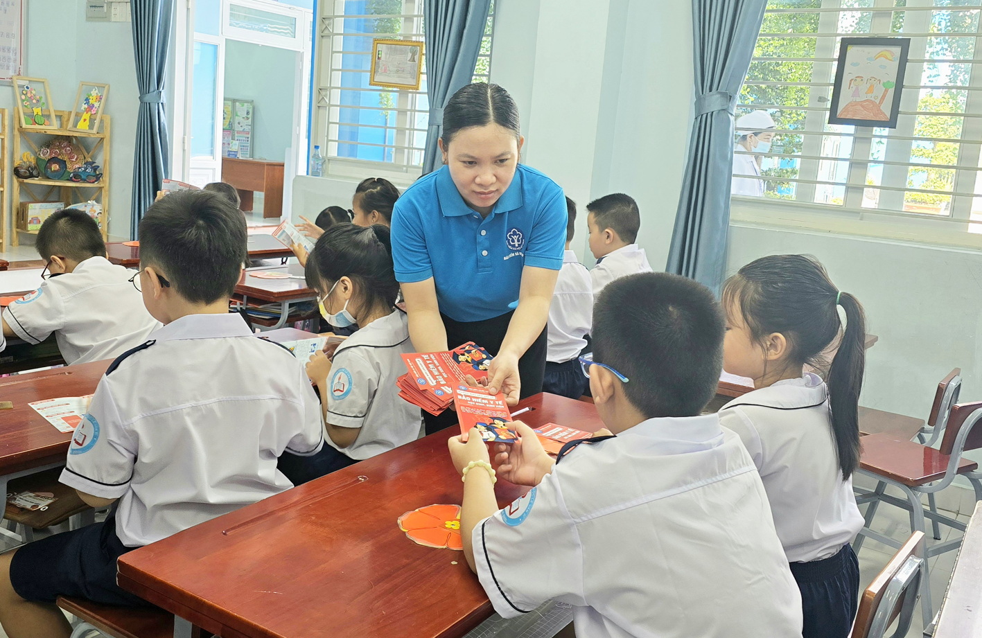 Cơ quan Bảo hiểm xã hội quận Tân Bình phát tờ gấp tuyên truyền bảo hiểm y tế đến học sinh và gửi về cho phụ huynh