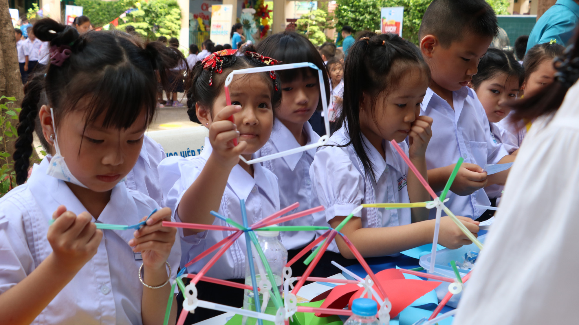 Học sinh lớp Một chăm chú làm các sản phẩm thủ công dưới sự hướng dẫn của các cô giáo - Ảnh: Trang Thư