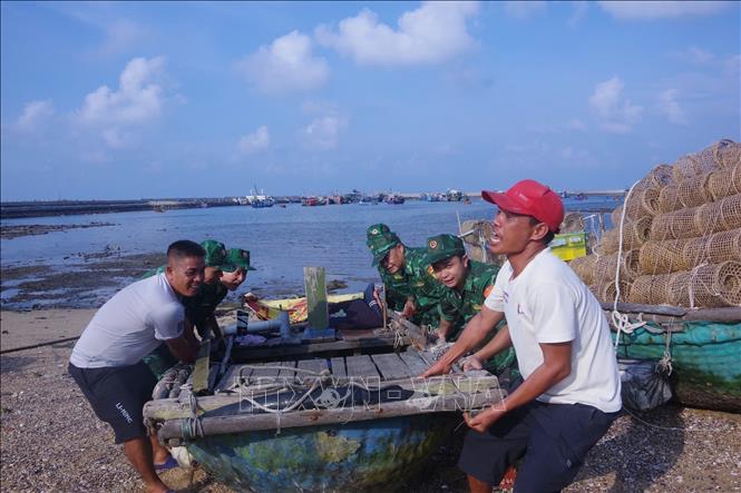 Lực lượng chức năng hỗ trợ ngư dân huyện đảo tiền tiêu Bạch Long Vĩ (Hải Phòng) di chuyển tàu thuyền lên bờ tránh bão. Ảnh: TTXVN phát