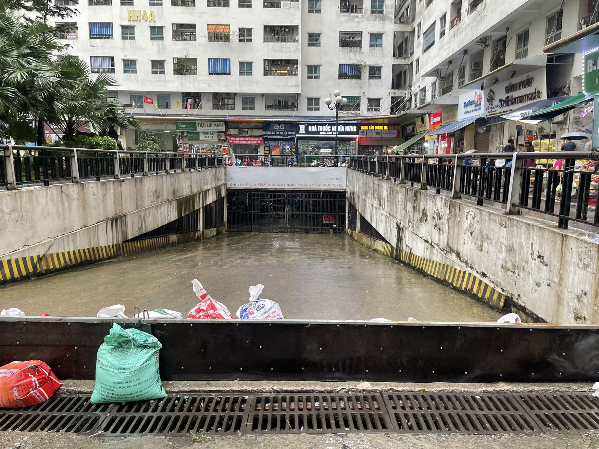 Người dân dùng bao cát, bàn ghế để chặn, chống bão. Một số cửa hàng trên đường Phạm Văn Đồng (Cầu Giấy, Hà Nội) còn dùng xe container chặn trước cửa, phòng gió giật vỡ kính.