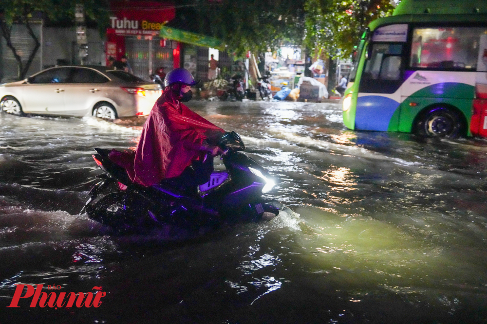 Nước dâng cao ngập lụt kèm mưa lớn khiến người dân di chuyển khó khăn trong đêm.