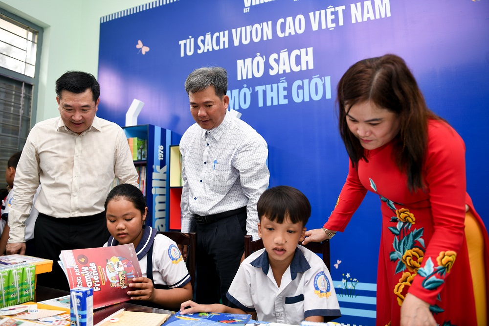 Các em học sinh khám phá tủ sách mới do Vinamilk trao tặng tại thư viện trường - Ảnh: Vinamilk