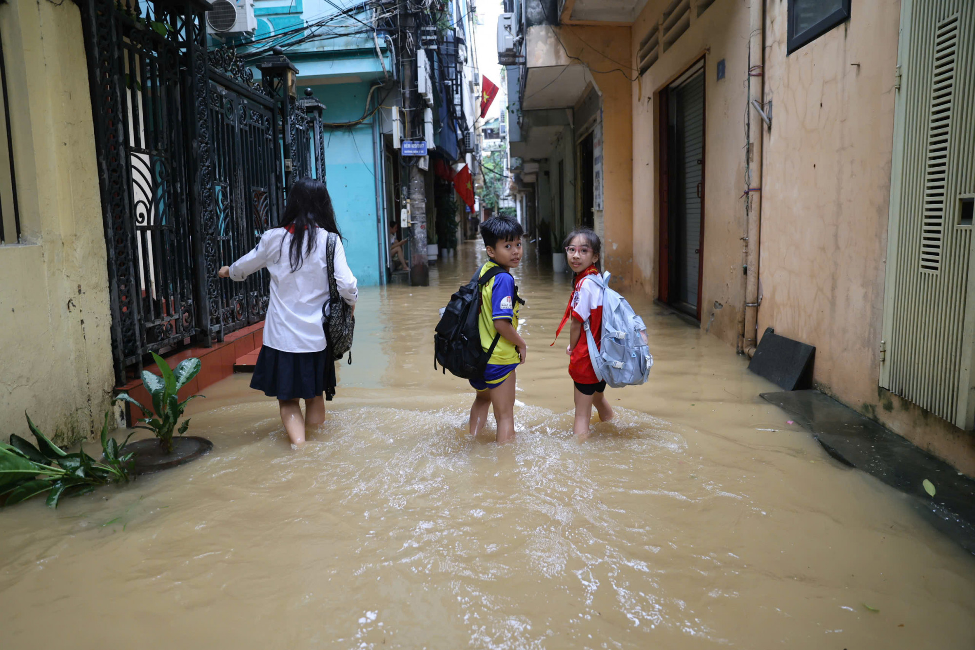 Các em học sinh vẫn phải lội nước đến trường trong những ngày này.