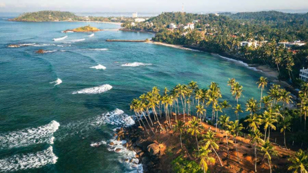  bãi biển Mirissa tọa lạc tại phía Nam Sri Lanka. Bãi cát trắng trải dài vô tận, làn nước biển trong vắt cùng hàng dừa đung đưa trong gió làm cho du khách cứ mê mẩn biển Mirissa mãi không muốn về. Có thể nói biển Mirissa sở hữu vẻ đẹp hoang sơ và kỳ vĩ, vậy nên khách du lịch đến đây ngoài việc tận hưởng sắc trời và gió biển còn có thể chèo thuyền kayak để thăm thú cảnh quan tuyệt mỹ xung quanh. Khi hoàng hôn buông xuống, bãi biển Mirissa trở nên thơ mộng và lãng mạn hơn bao giờ hết, bạn có thể đến những quầy bar, nhà hàng dọc bờ biển Mirissa để thưởng thức những món ẩm thực địa phương cùng những ly cocktail mang hương vị đặc trưng của vùng đất Tây Âu này.