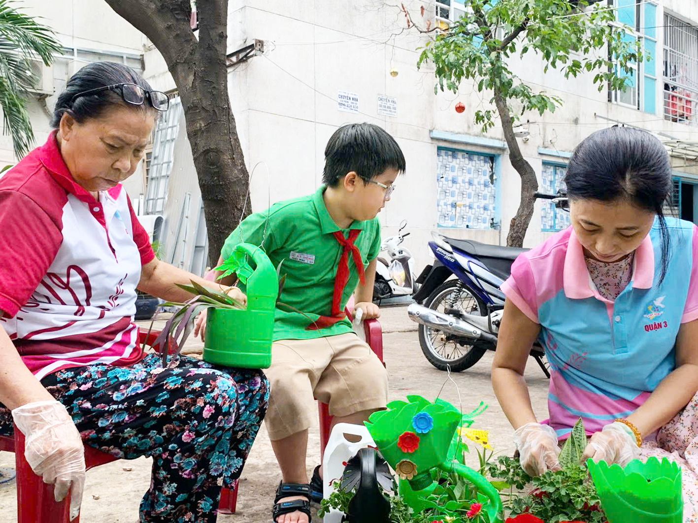 Bà Nguyễn Thị Thanh Khuê (bìa trái) cùng Hội Phụ nữ tái chế chậu hoa từ ve chai