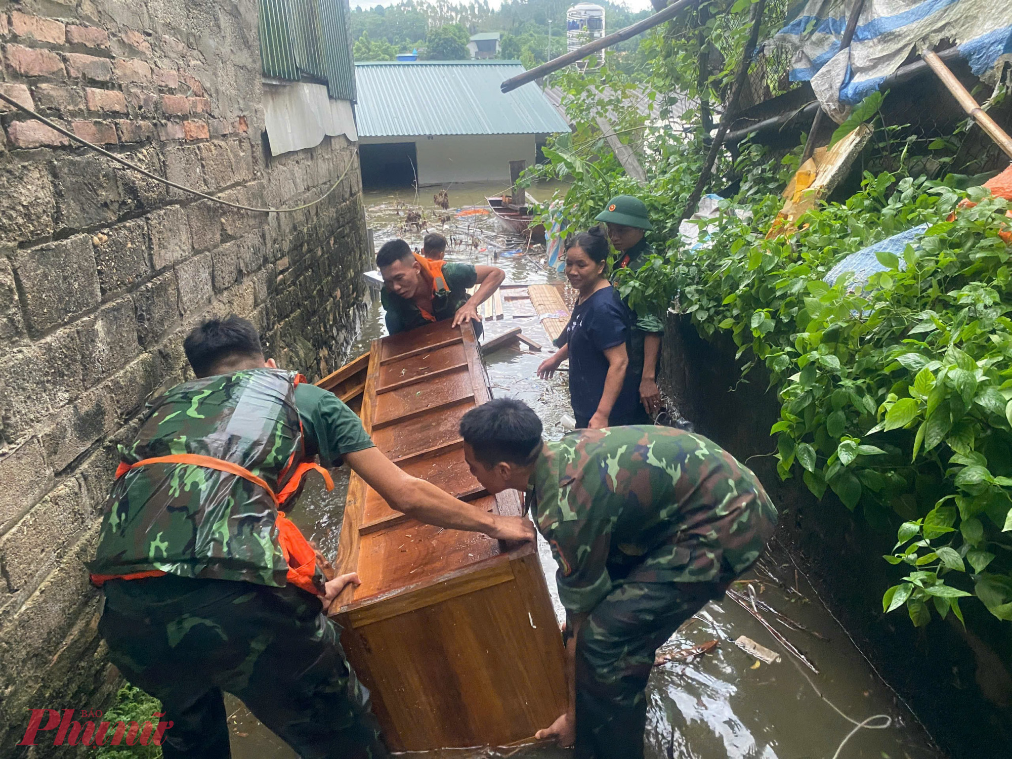 Khi lũ quét qua, nước dâng cao, những người lính  xông pha vào từng con ngõ đang ngập để khuân đồ đạc, chằng chống nhà cửa cho người dân. 