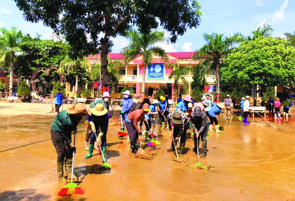 Các thầy cô giáo trong và ngoài huyện Bảo Yên, tỉnh Lào Cai hỗ trợ giáo viên Trường THCS số 1 Phố Ràng dọn dẹp bùn đất để sớm đón học sinh - Ảnh: T.N.