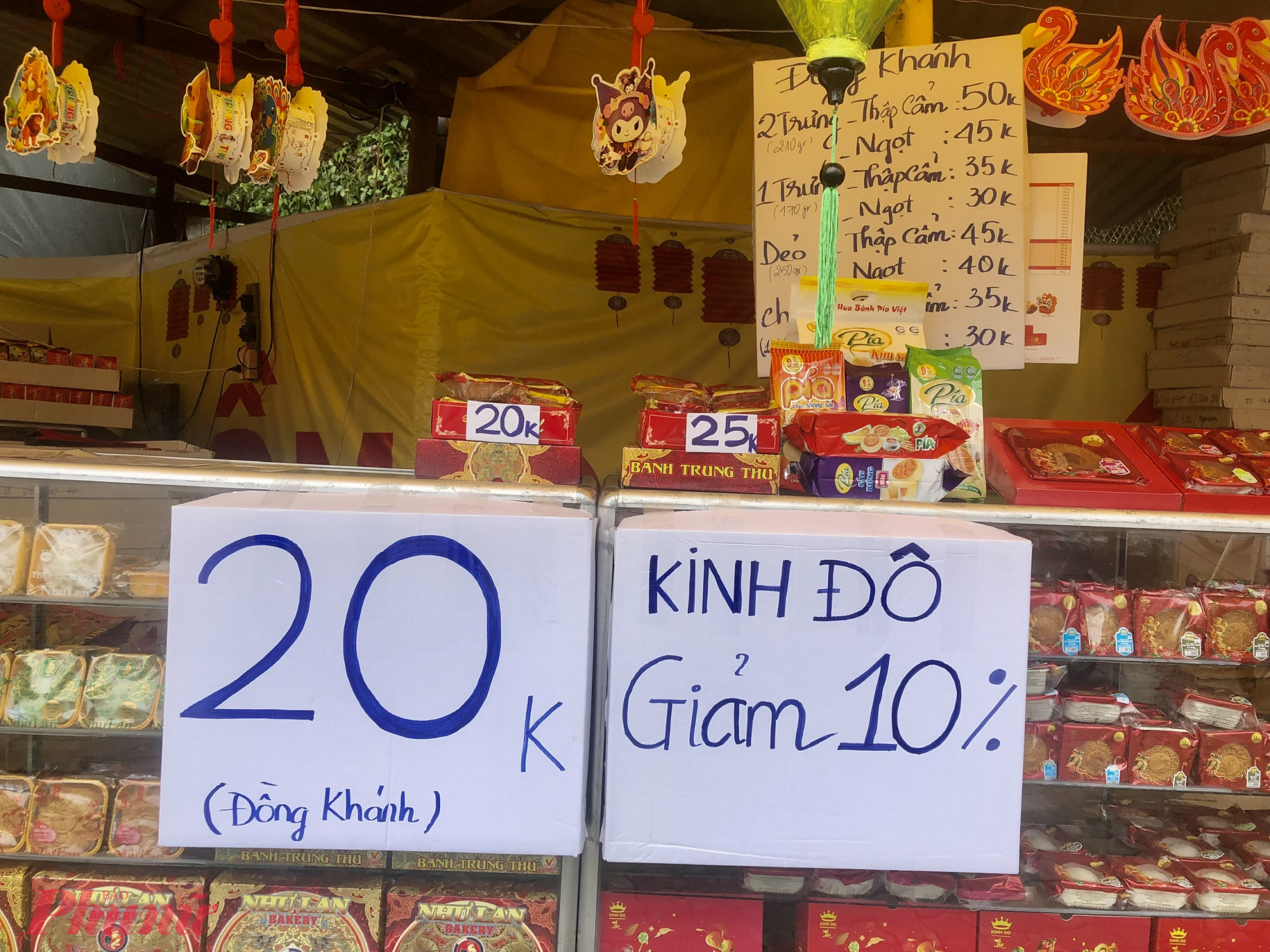 Phía bên trong quầy, có thêm tấm bảng Đồng Khánh 20K, Kinh Đô giảm giá 10%