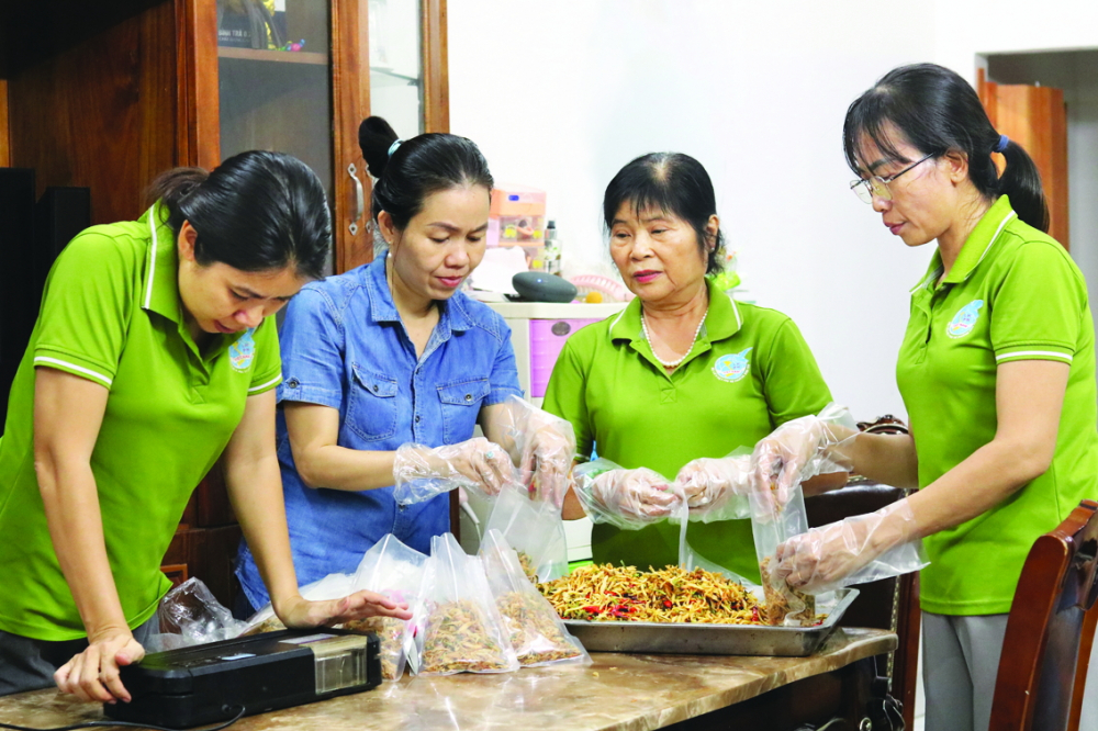 Chị Nguyễn Thị Thu Nhi (thứ hai từ trái qua) cùng cán bộ, hội viên phụ nữ phường Bình Thọ, TP Thủ Đức làm món khô gà lá chanh gửi tiếp sức bà con tỉnh Lào Cai - ẢNH: MẪN NHI