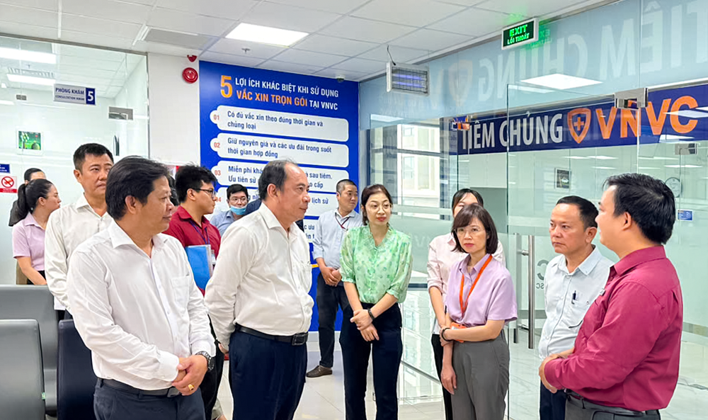 PGS.TS Tăng Chí Thượng (hàng đầu, thứ hai từ trái qua) và Phó giám đốc Trung tâm Kiểm soát bệnh tật TPHCM - ThS.BS Lê Hồng Nga (thứ ba từ phải qua) đến thăm và giám sát việc triển khai chiến dịch tiêm vắc xin sởi miễn phí cho trẻ từ 1-10 tuổi sáng 17/9 tại VNVC quận 8 (TPHCM) - Ảnh: Mộc Thảo