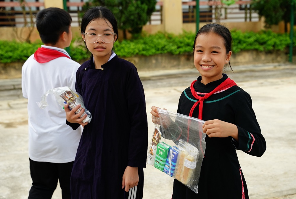 Nhận những phần quà gồm sữa tươi, sữa đặc của Vinamilk và bánh mì, các em đều hớn hở, vui thích vì đã có thể kịp đón Trung thu sau những ngày bão lũ - Ảnh: Vinamilk