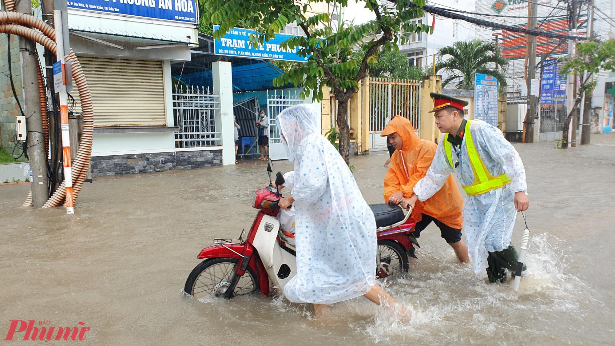 Lực lượng chức năng hỗ trợ người dân đi qua khu vực ngập sâu do ảnh hưởng triều cường vào năm 2023