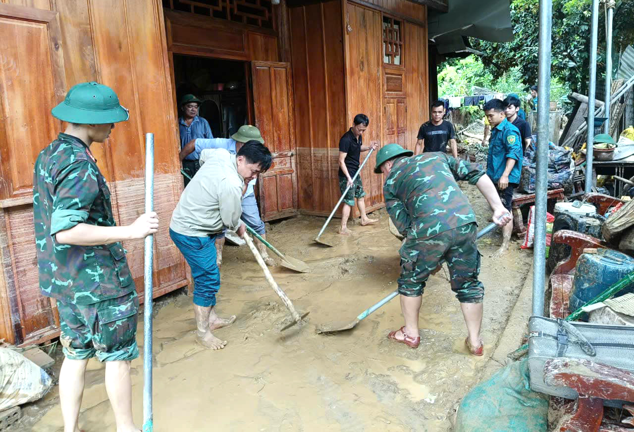 Lực lượng Ban Chỉ huy quân sự huyện Tương Dương hỗ trợ người dân xã Lượng Minh dọn dẹp bùn đất - Ảnh: Hoàng Long