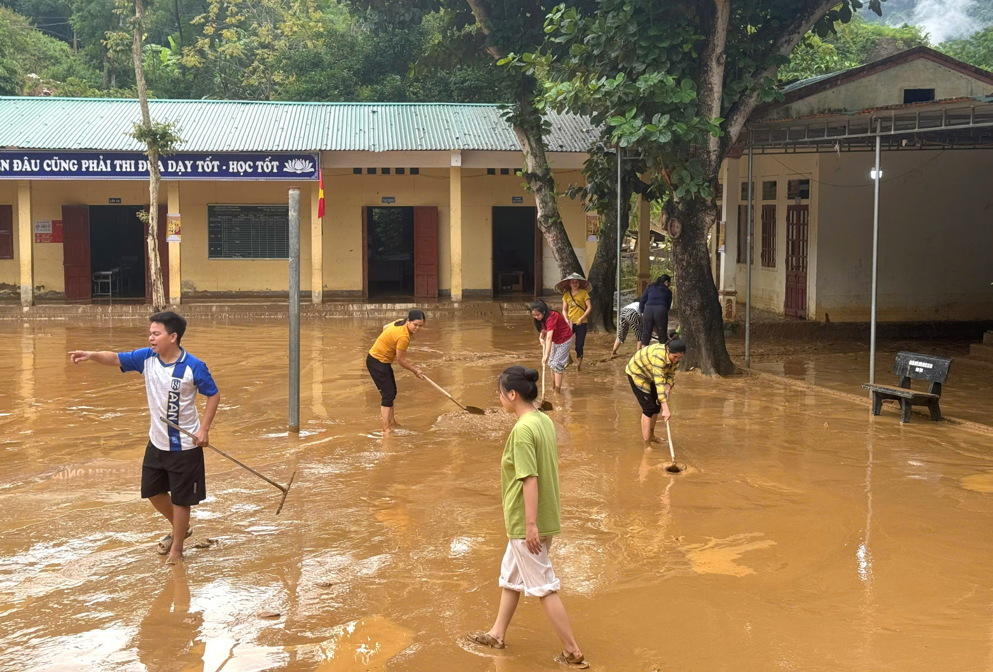 Giáo viên Trường phổ thông dân tộc bán trú tiểu học Lượng Minh dọn dẹp bùn đất - Ảnh: Văn Thanh