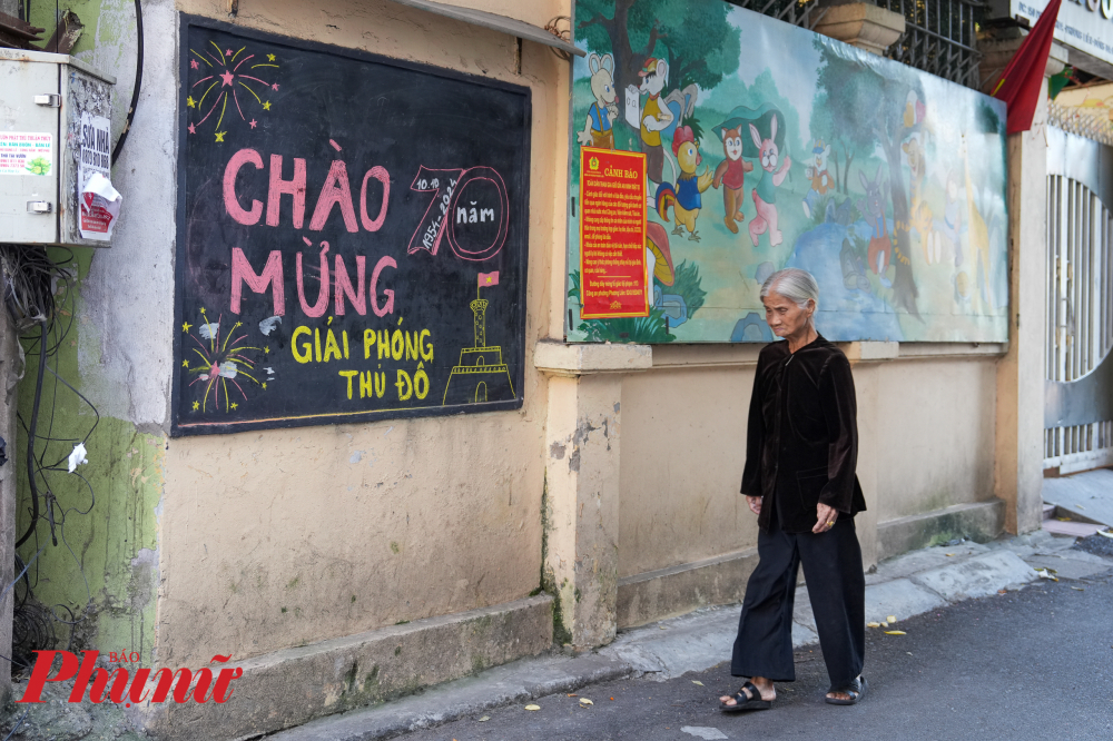 Bà Nguyễn Thị Tình (phố Kim Hoa, quận Đống Đa, Hà Nội) chia sẻ: 'Chúng tôi tự vẽ bằng phấn màu đơn giản vậy thôi nhưng rất ý nghĩa, người dân ai cũng thích. Trang trí như thế này vừa hiệu quả lại vừa tiết kiệm'.