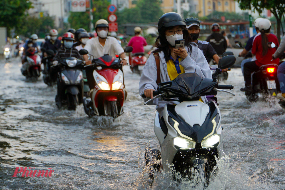 Khoảng 17h, nước trên kênh Tẻ dâng cao tràn qua đường Trần Xuân Soạn khiến đoạn đường này bị ngập sâu - Ảnh: Vũ Quyền