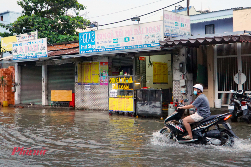 Hàng quán bên đường trở nên ế ẩm, vắng khách vì nước dâng cao - Ảnh: Vũ Quyền