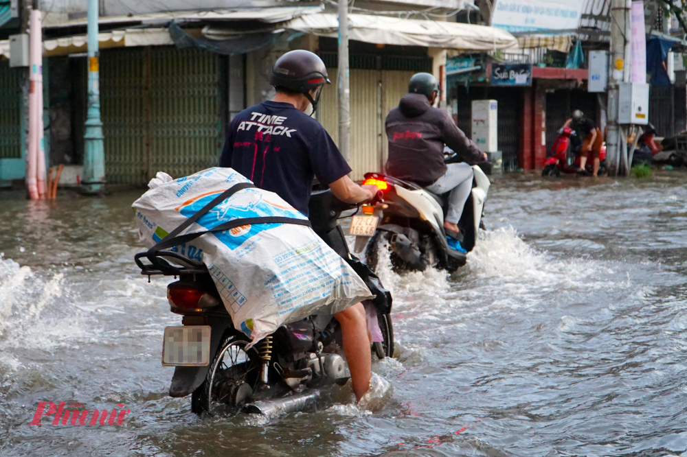 Nhiều phương tiện chết máy khi di chuyển qua khu vực nước ngập sâu - Ảnh: Vũ Quyền