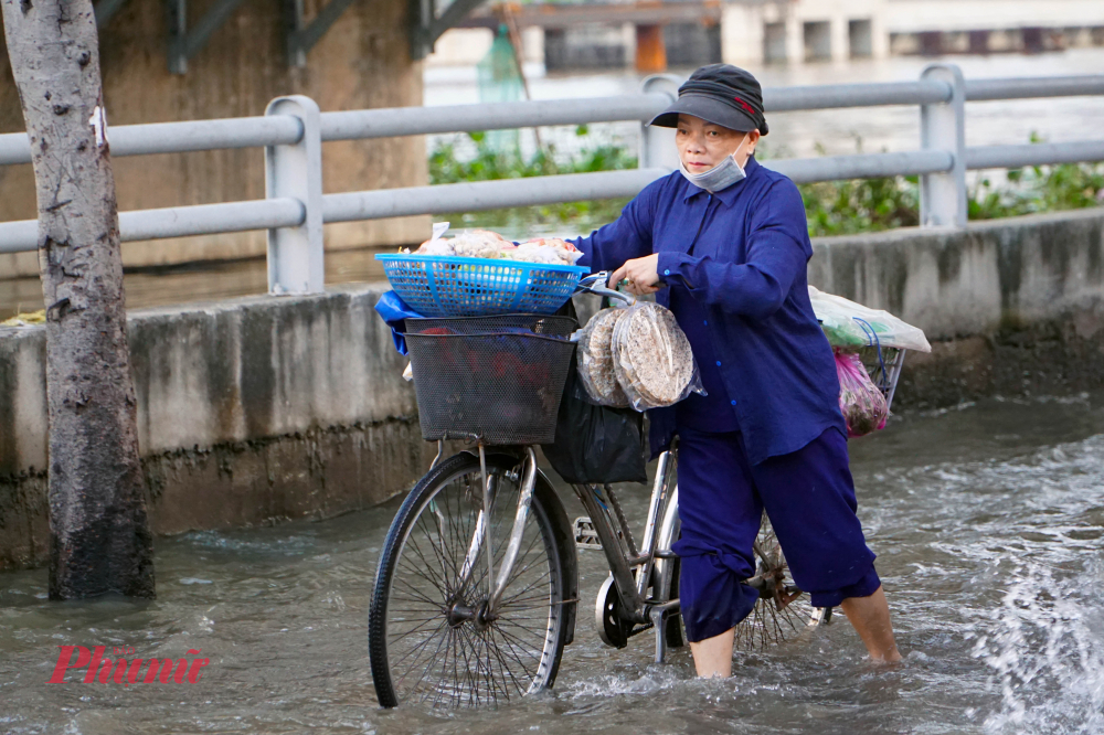 Người đi xe đạp cũng phải xuống dẫn bộ qua đoạn ngập - Ảnh: Vũ Quyền