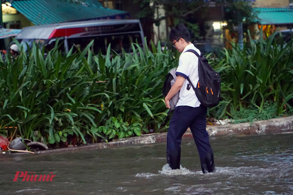 Học sinh lội nước để trở về nhà sau giờ tan trường - Ảnh: Vũ Quyền