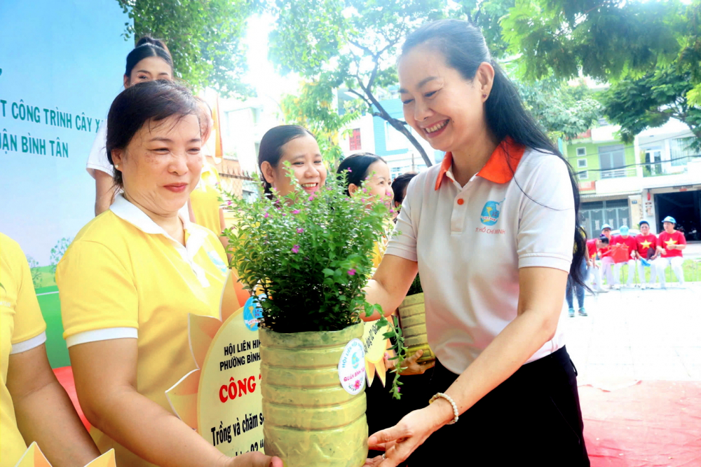 Bà Lâm Thị Ngọc Hoa (bìa phải) - Phó chủ tịch thường trực Hội LHPN TPHCM - tặng cây xanh cho nữ công nhân, hội viên phụ nữ quận Bình Tân - ẢNH: MẪN NHI