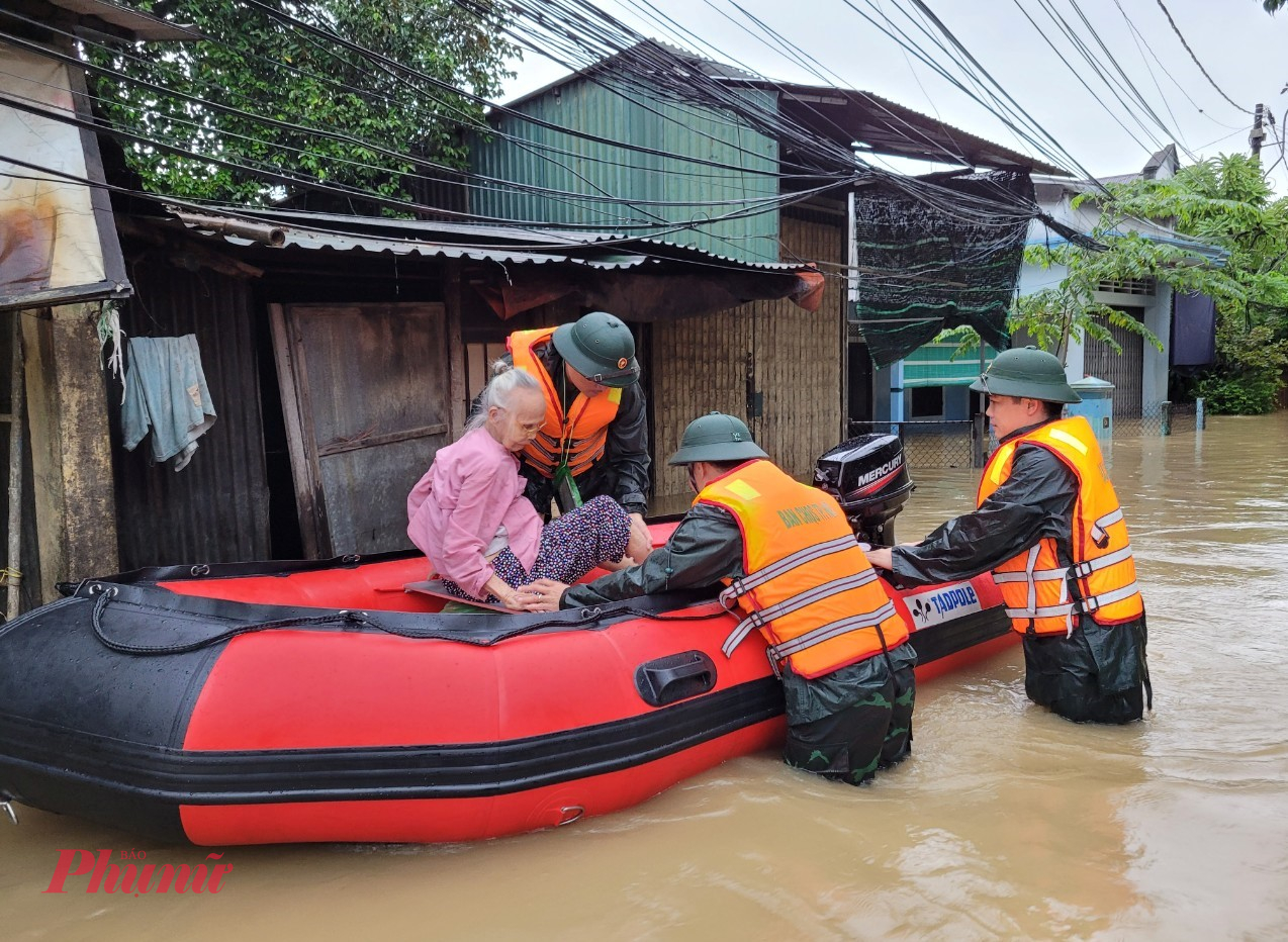 Lực lượng quân đội hỗ trợ đưa người dân vùng thấp trũng đến nơi ở an toàn - Ảnh: Tư liệu T.H