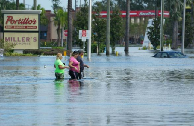 Mọi người đi bộ qua những con phố ngập lụt ở khu phố Đông Nam Seminole Heights của Tampa, Florida, bị ngập lụt do Bão Milton, vào ngày 10 tháng 10 năm 2024