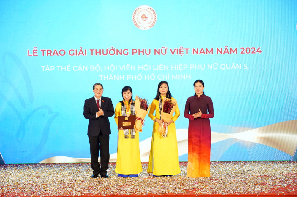 Ông Nguyễn Đức Hải (bìa trái) - Phó chủ tịch Quốc hội - và bà Hà Thị Nga (bìa phải) - Chủ tịch Hội LHPN Việt Nam - trao giải thưởng Phụ nữ Việt Nam cho đại diện Hội LHPN quận 5 vào ngày 12/10 - ẢNH: BẢO KHANG