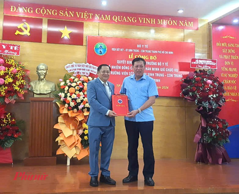 Tiến sĩ Giang Hán Minh (bên trái) nhận quyết định tân viện trưởng Viện Sốt rét - Ký sinh trùng - Côn trùng TPHCM từ Thứ trưởng Bộ Y tế Đỗ Xuân Tuyên (bìa phải) - ảnh Phạm An