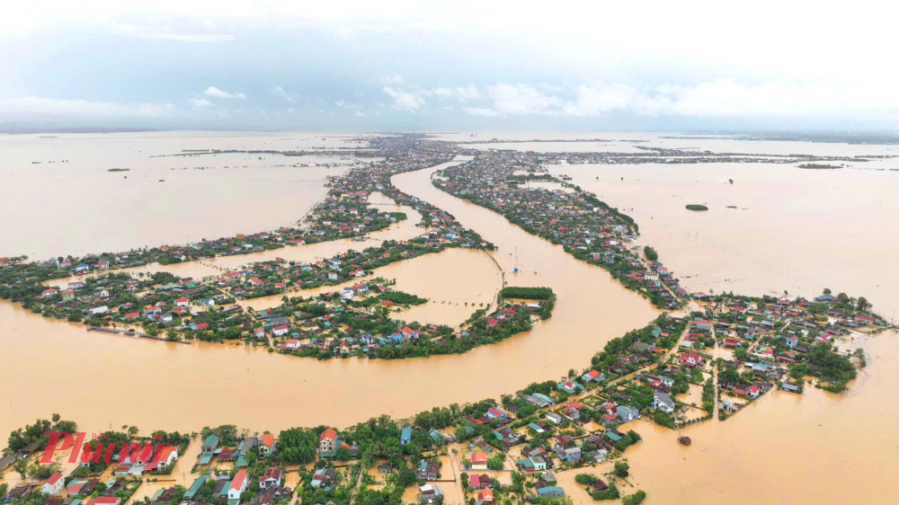 Từ cao nhìn xuống, những nóc nhà của dân vùng lũ Lệ Thuỷ trơ trọi giữa biển nước mênh mông.-Ảnh: Nguyễn Chiến