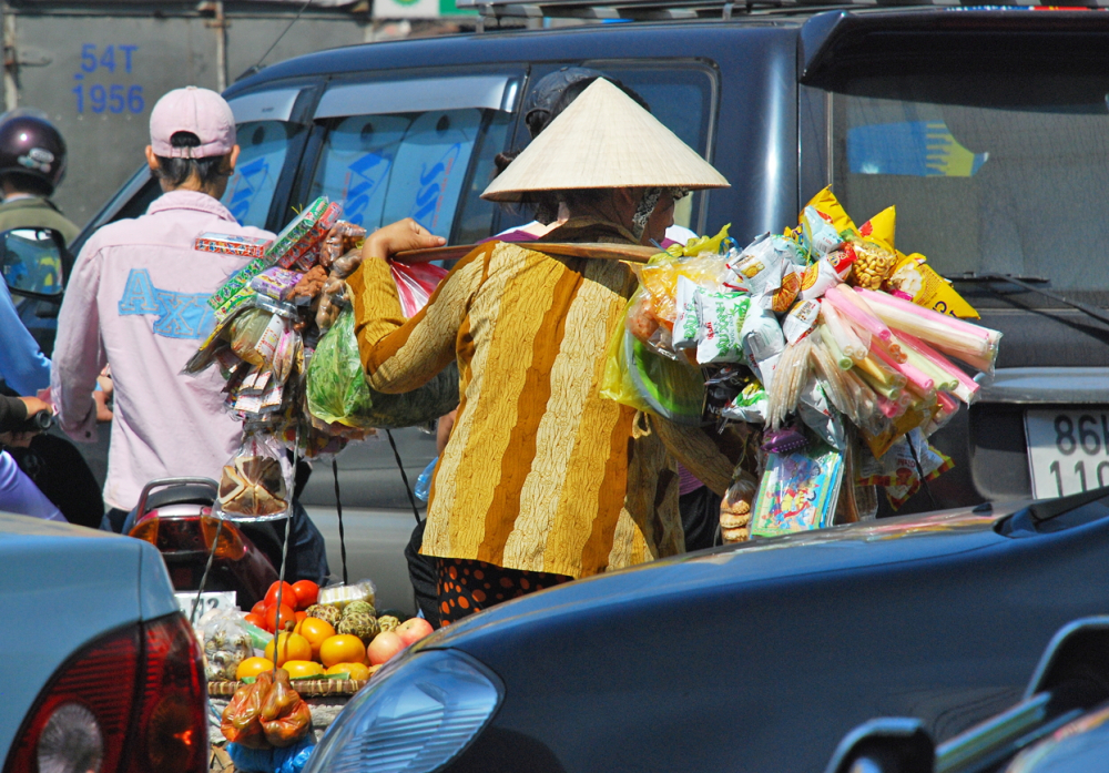 Một phụ nữ gánh hàng rong giữa trời nắng nóng ở công viên Tao Đàn, quận 1, TPHCM - ẢNH: PHÙNG HUY