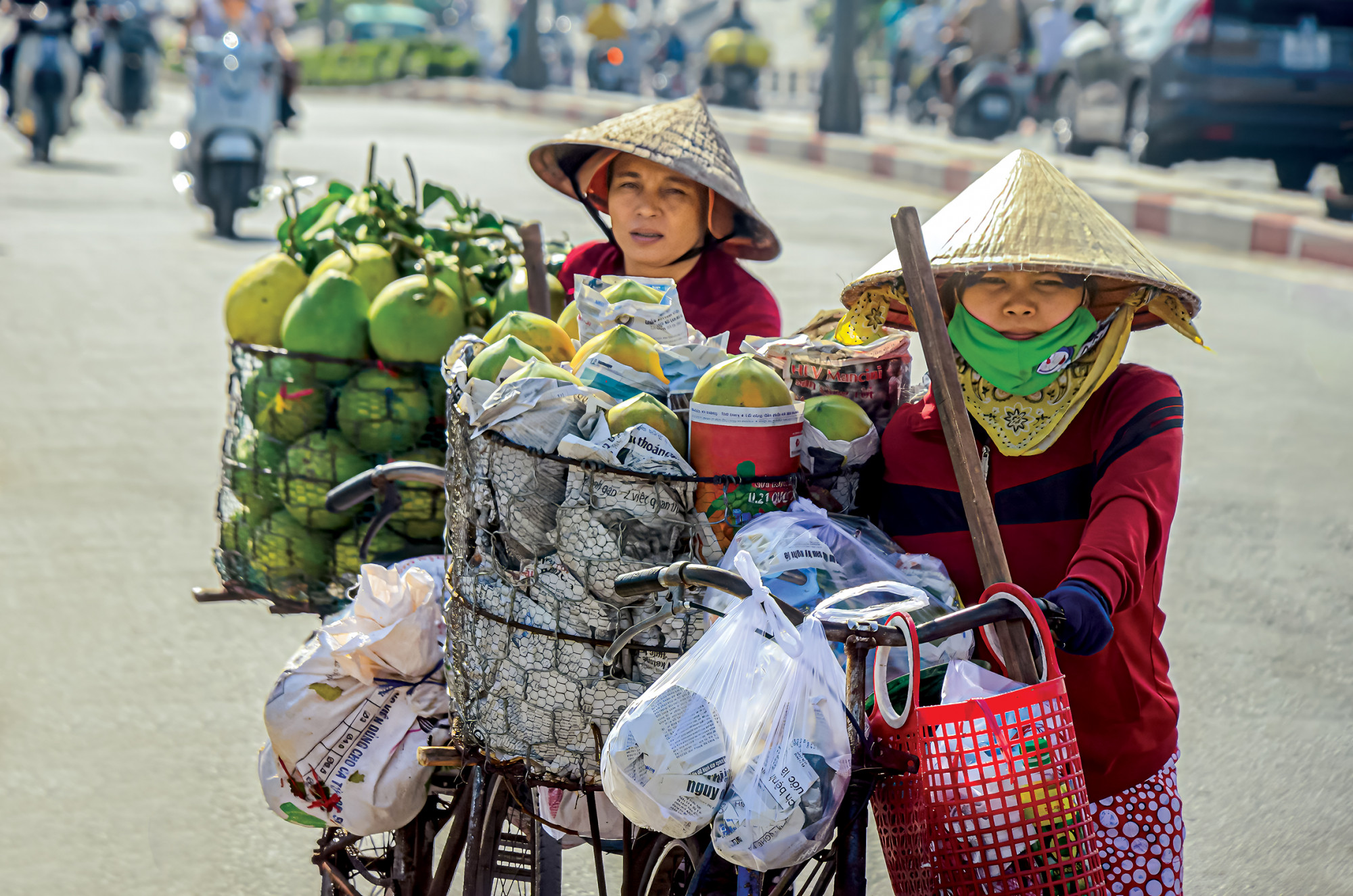 2 phụ nữ đẩy xe bán hàng rong ở cầu Ông Lãnh, quận 1, TPHCM dưới trời nắng gắt, nền nhiệt cao ẢNH: PHÙNG HUY