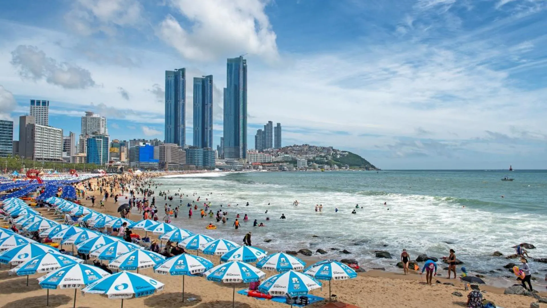 Dành một ngày ở bãi biển Haeundae Bãi biển Haeundae, Busan | Nguồn ảnh: visitbusan Một trong những bãi biển nổi tiếng nhất ở Busan nếu không muốn nói là Hàn Quốc, Bãi biển Haeundae là nơi lý tưởng để ngắm cảnh đẹp như tranh vẽ, tham gia các hoạt động dưới nước và thư giãn, tránh xa sự hối hả và nhộn nhịp của cuộc sống thành phố. Vùng nước nông của bãi biển rất lý tưởng để bơi lội và các môn thể thao dưới nước nhẹ nhàng khác, khiến nơi đây trở thành một trong những địa điểm du lịch được yêu thích nhất ở Busan. Du khách cũng có thể đi dạo quanh Công viên Dongbaek hoặc dành thời gian ở Quảng trường Dân gian, nơi người dân địa phương đắm mình vào các trò chơi cờ bàn với bạn bè và gia đình, cổ vũ cho những đối thủ yêu thích của họ.  Giờ mở cửa: Mở cửa 24/7  Vé: NA