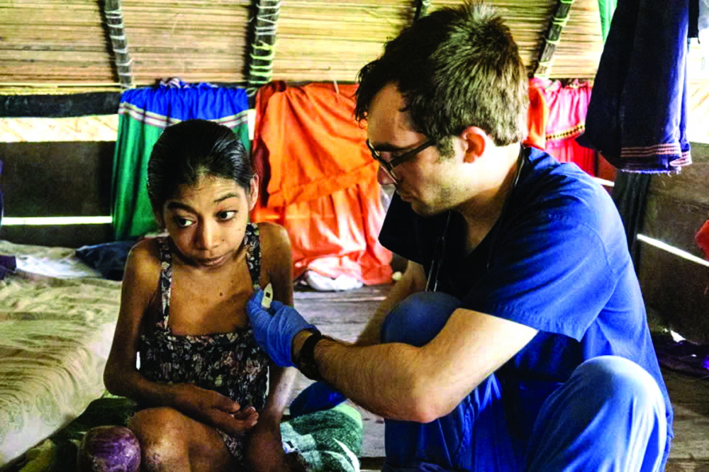 Devin Herald - tình nguyện viên của Floating Doctors - đang đo nhiệt độ cho Omayra Abrego tại nhà của cô ở làng Wari, Panama