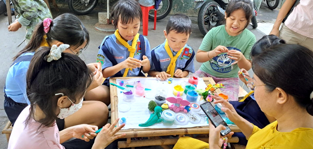 Nhiều ông bố, bà mẹ đưa con đến chợ quê để con được học,  chơi các trò chơi dân gian