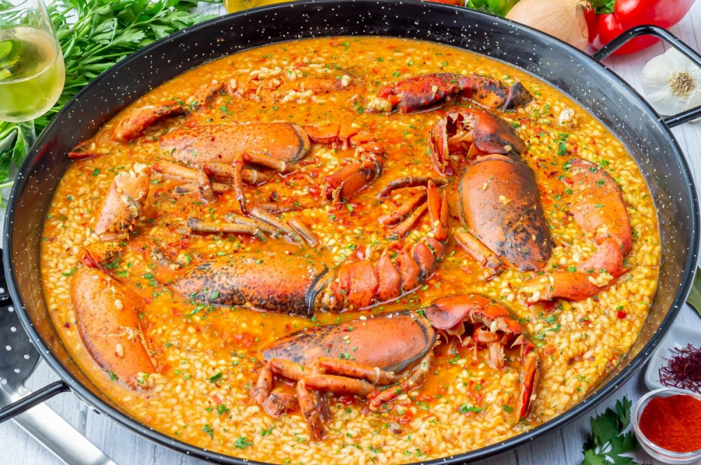 Arroz con bogavante là món cơm truyền thống tại Tây Ban Nha có nguồn gốc từ Valencia, đây là món cơm nổ tiếng Món cơm hầm này thường được làm từ hỗn hợp cơm tròn như arroz bomba, tôm hùm, nước dùng cá, rượu vang trắng, tôm, hành tây, tỏi, ớt chuông, cà chua, ớt bột, nghệ tây, dầu ô liu và gia vị.  Các thành phần được xào trong chảo, sau đó ninh trong nước dùng cho đến khi mọi thứ chín hoàn toàn. Nên có nước còn lại trong chảo, vì món ăn này phải có nước dùng và cơm phải nổi trong nước dùng lỏng. Đậy chảo và để món ăn nghỉ trong vài phút trước khi phục vụ. i 