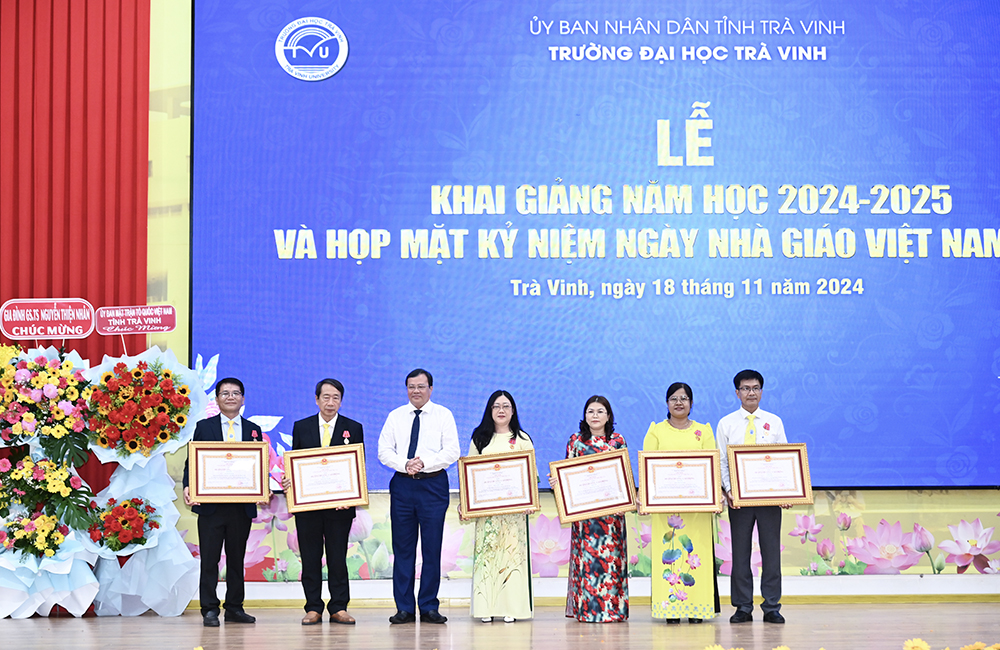 Ông Lê Văn Hẳn - Chủ tịch UBND tỉnh Trà Vinh thừa ủy quyền, trao tặng Huân chương Lao động hạng Nhất cho giáo sư - tiến sĩ Phạm Tiết Khánh và các cá nhân nhận Huân chương Lao động hạng Ba - Ảnh: Đại học Trà Vinh