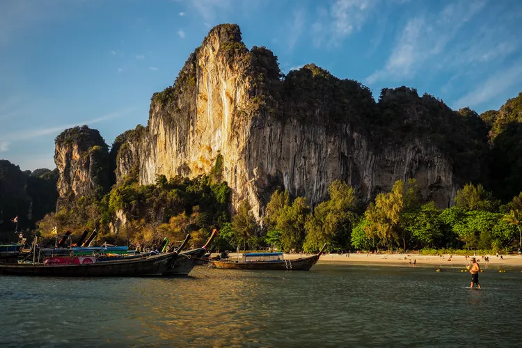  của 14 Bãi biển Railay, Krabi Những chiếc thuyền neo đậu tại bãi biển Railay bên những ngọn núi đá vôi lớn Bãi biển Railay ở Krabi, Thái Lan. Lauren DeCicca/Du lịch + Giải trí Bạn có thể đã thấy bãi biển này được quảng cáo rầm rộ ở Thái Lan trong thập kỷ qua. Nó cực kỳ nổi tiếng, nhưng có lý do chính đáng. Chỉ có thể đến bằng thuyền, những vách đá vôi cao chót vót ở hai bên tạo nên những bức ảnh kỳ nghỉ hoành tráng và hoạt động leo núi đá nghiêm túc. Có thể bơi ở phía tây của bãi biển, nhưng cảnh quan ấn tượng mới là điểm thu hút chính ở đây. Lauren DeCicca/Du lịch + Giải trí