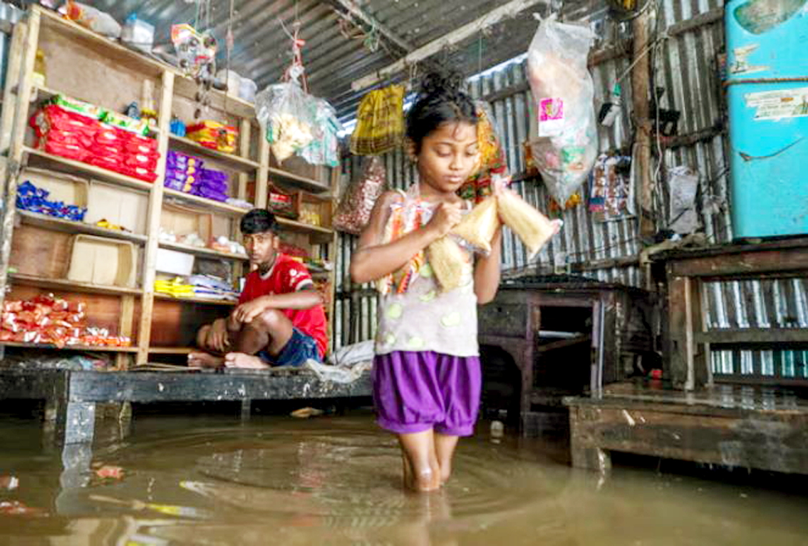 Một bé gái lội qua nước lũ để mua thực phẩm cho gia đình ở làng Shimultala, Bangladesh - ẢNH: ABDUL GONI (UNICEF)