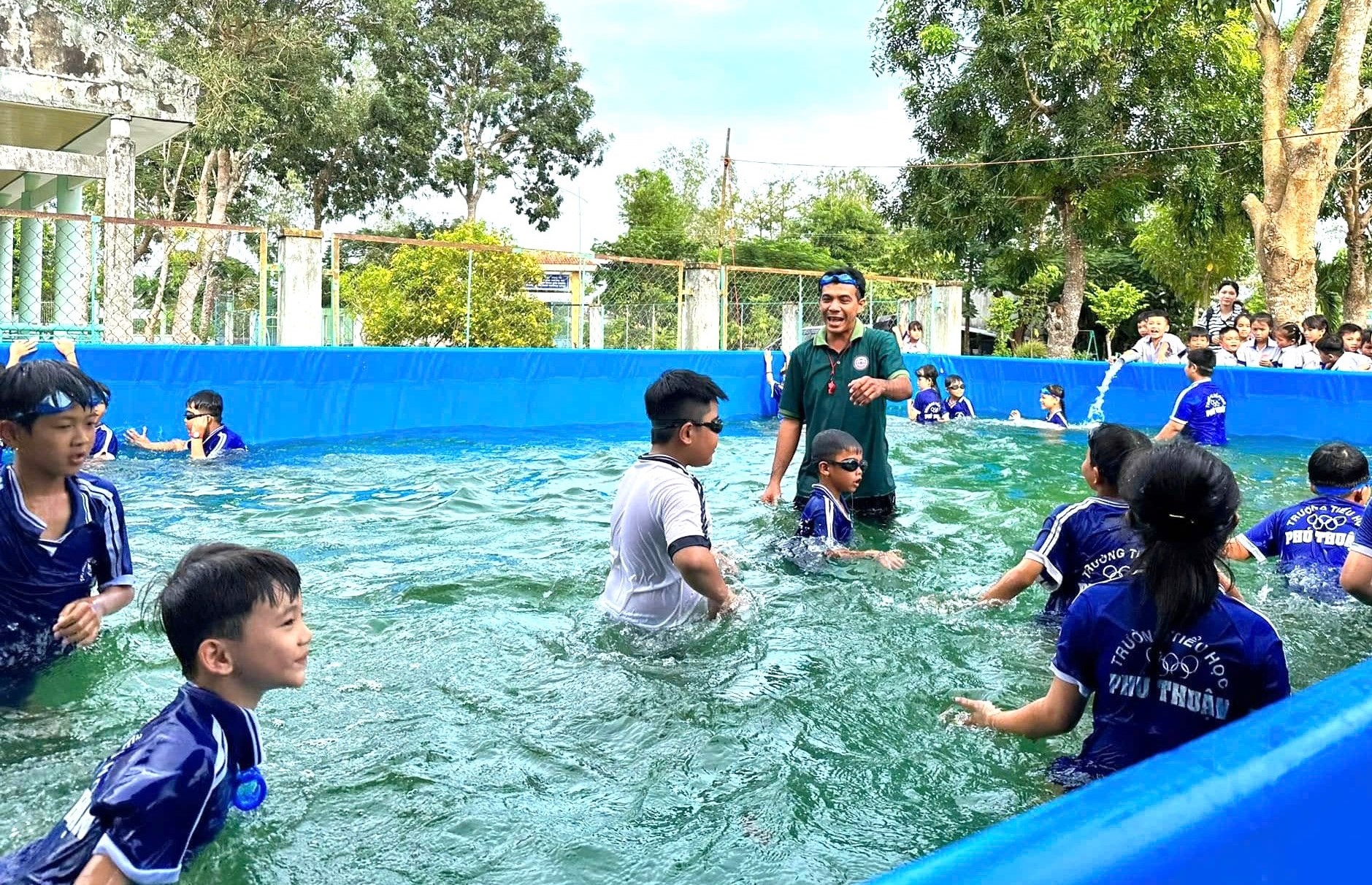 Thầy trò Trường tiểu học Phú Thuận tập bơi trong chiếc hồ mới do Quỹ Phát triển Tài năng Việt trao tặng - Ảnh: Quỹ Phát triển Tài năng Việt