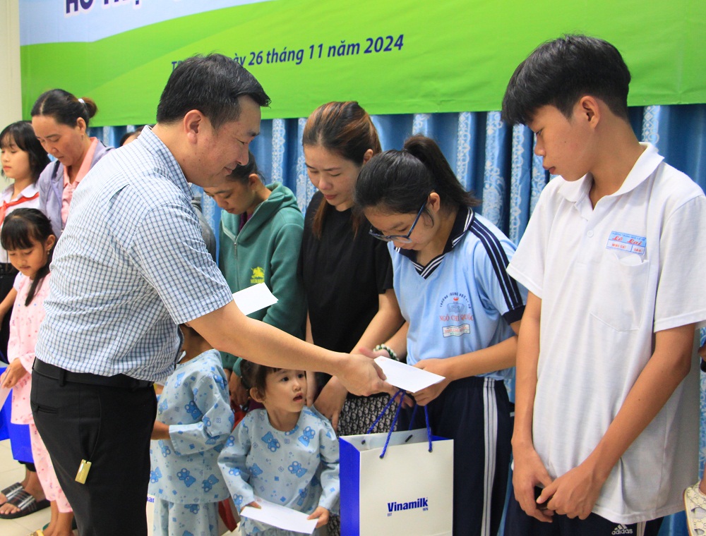 Ông Đỗ Thanh Tuấn, đại diện Vinamilk, trao hỗ trợ và các món quà đến các bệnh nhi tại chương trình “Cứu trẻ em bị bệnh tim bẩm sinh” năm 2025 - Ảnh: Vinamilk