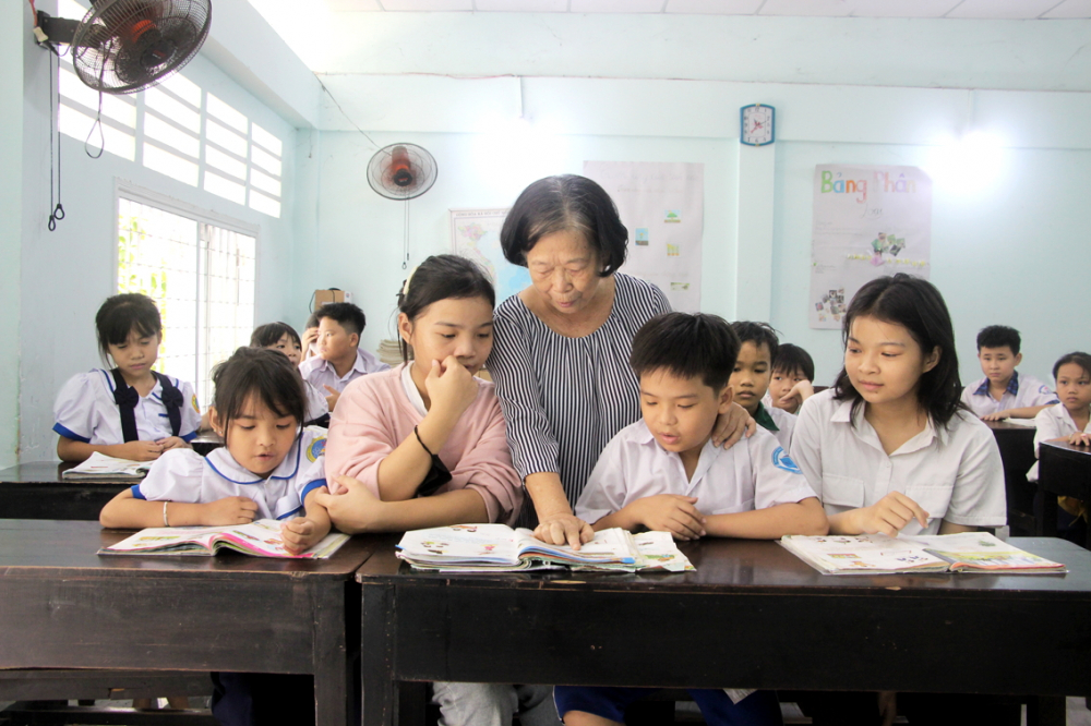 Cô Nguyễn Thị Hằng (đứng) đang dạy môn tiếng Việt cho 4 chị em của Trâm Anh tại Trung tâm Học tập cộng đồng phường Thạnh Lộc, quận 12 - ẢNH: NGUYỄN LOAN