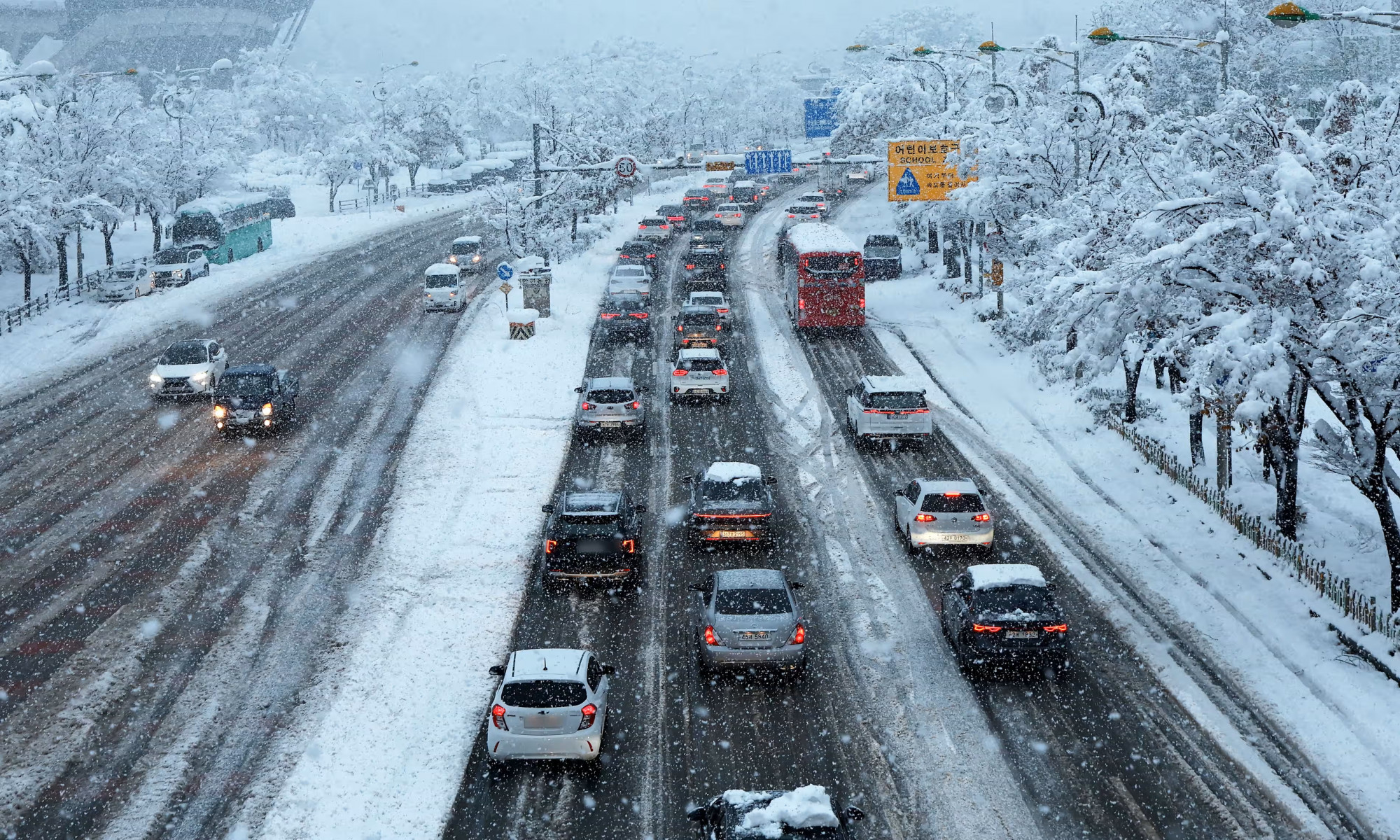 Xe ô tô di chuyển chậm trên một con đường ở Suwon, cách Seoul, Hàn Quốc 30km về phía nam trong ngày thứ hai có tuyết rơi dày 28/11 - Ảnh: YONHAP/EPA