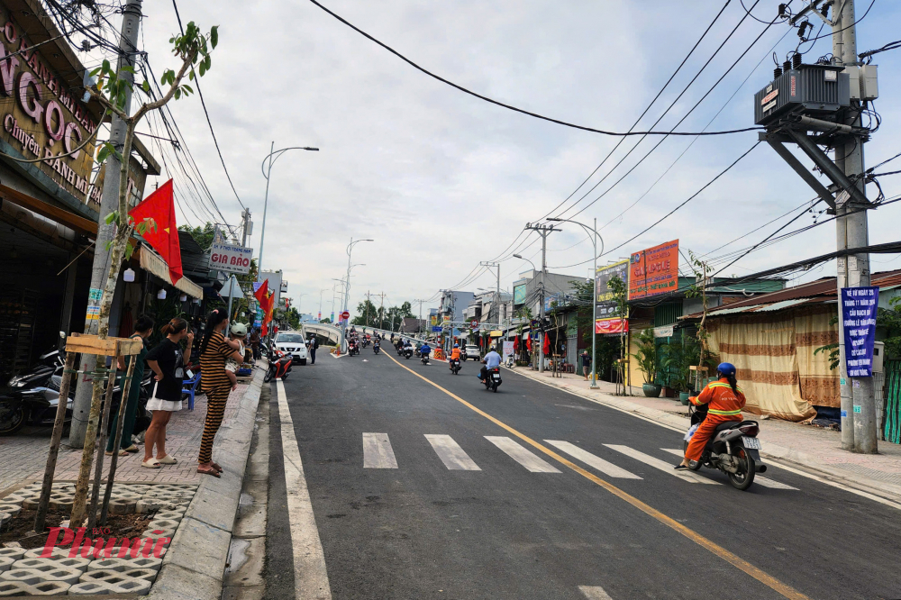 Chị Đinh Thị Thúy (ngụ quận 7) cho hay, trong thời gian cầu Rạch Đỉa mới xây dựng, hằng ngày chị đều phải đi vòng qua đường Nguyễn Hữu Thọ để đưa con qua huyện Nhà Bè học. Tuy nhiên, đoạn đường trên lại thường kẹt xe và mất nhiều thời gian hơn. Hiện cầu mới hoàn thành xây dựng và đưa vào phục vụ người dân nên chị rất vui mừng. Trong ảnh: Người dân đổ xô ra xem xe cộ đi lại trên cầu Rạch Đỉa mới - Ảnh: Vũ Quyền