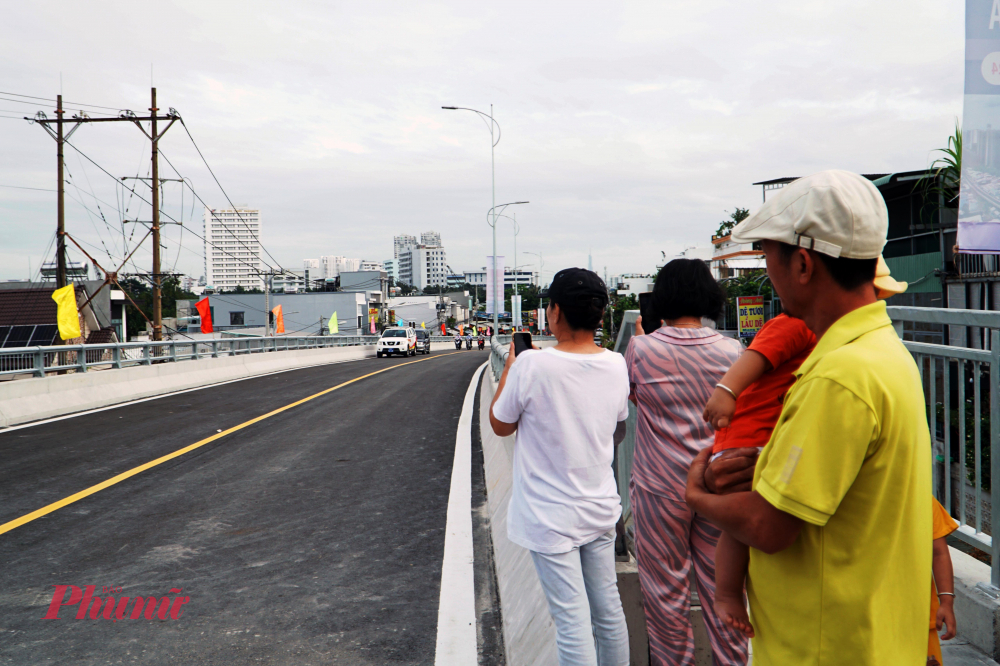 Nhiều người dân bên phía quận 7 và huyện Nhà Bè đã đi bộ lên cầu để quay phim, chụp ảnh, lưu lại khoảnh khắc cầu được thông xe - Ảnh: Vũ Quyền