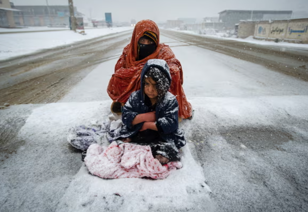 Một phụ nữ Afghanistan và đứa con của cô ăn xin trên đường từ Kabul đến Pol-e Alam. Sự bần cùng đã tăng vọt kể từ khi Taliban cấm phụ nữ làm hầu hết các công việc. Ảnh: Scott Peterson/Getty