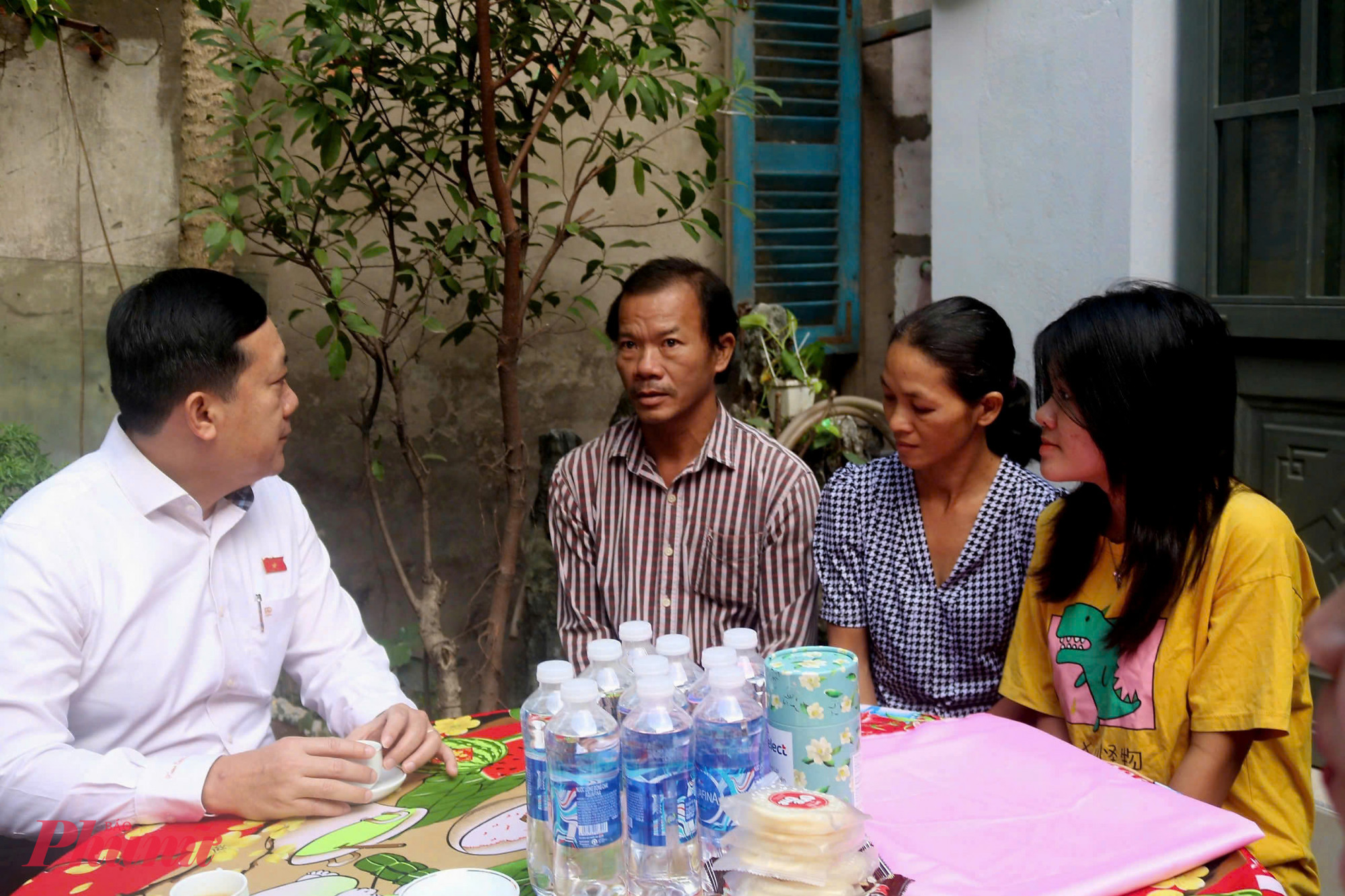 Đại biểu Hà Phước Thắng (bìa trái) động viên gia đình chị Hoa nỗ lực vượt qua khó khăn, chăm lo các con ăn học.