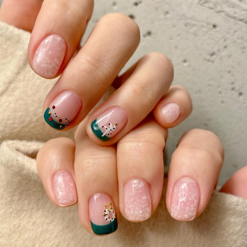 Nail màu xanh cây thông Noel: Mang màu xanh lá thông đặc trưng của mùa Giáng Sinh, mẫu nail kết hợp với họa tiết tuyết trắng mờ ảo, tạo nên vẻ đẹp dịu dàng và cuốn hút cho phái đẹp. Ngoài ra, hình ảnh cây thông Noel cùng dây đèn trang trí rực rỡ càng làm nổi bật lên đôi tay của các cô nàng. 